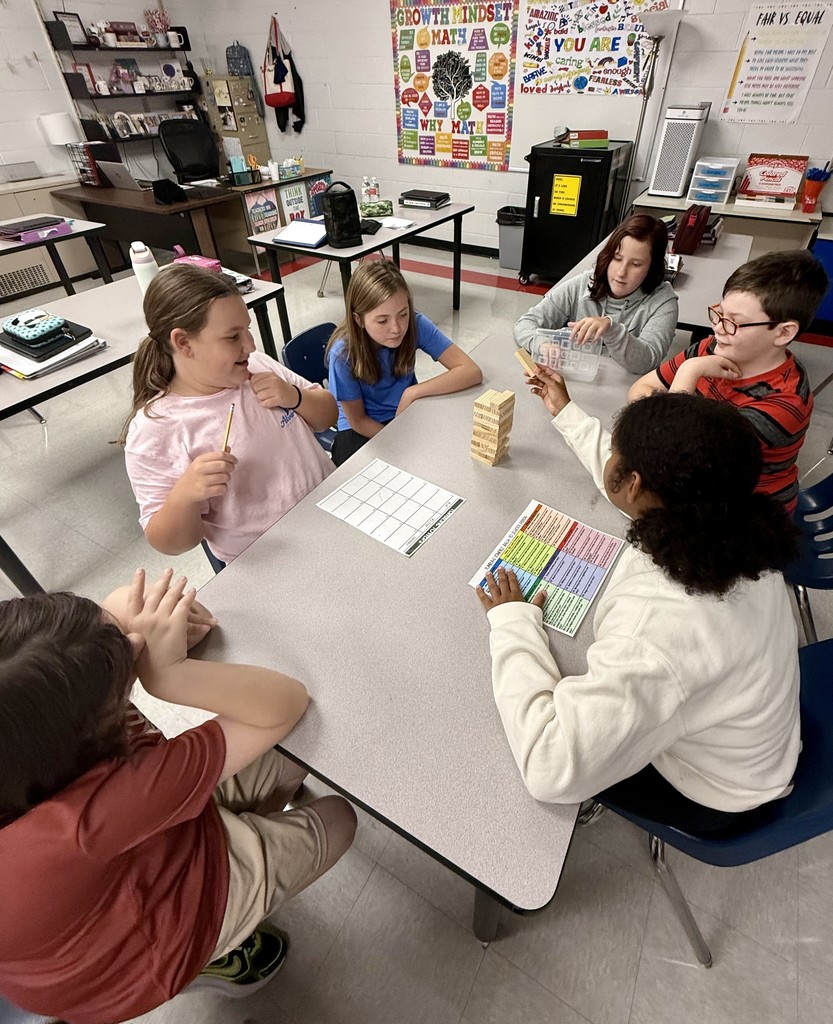 Students play Jenga at a table.