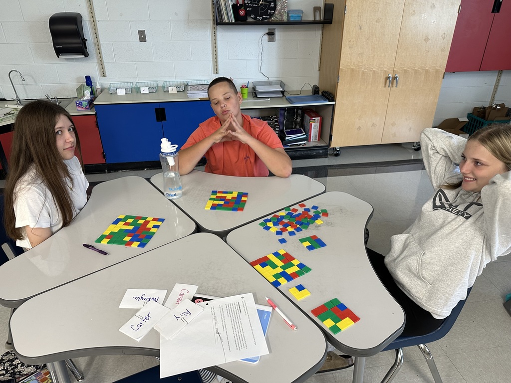 Students create perfect squares with tiles.