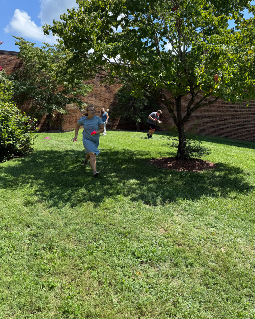 A student runs back to her team after she matched a perfect square to a square root.