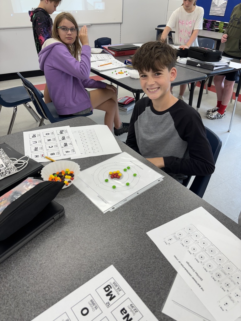 A student uses candy to model the structure of atoms.