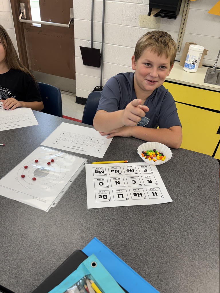 A student uses candy to model the structure of atoms.