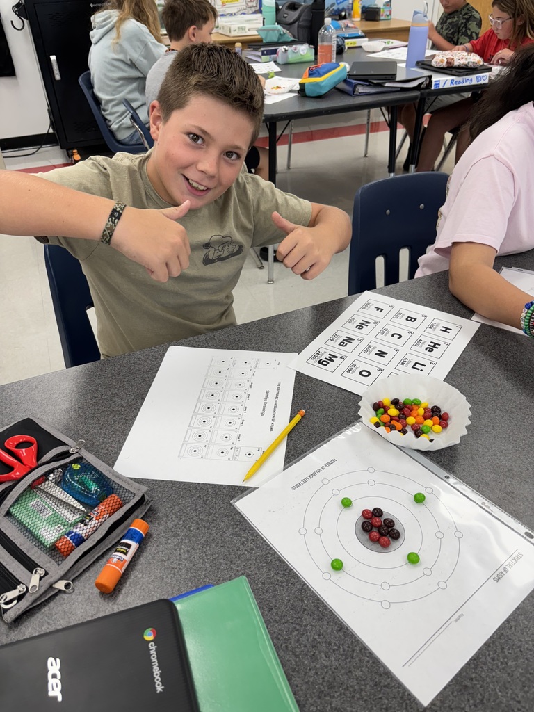 A student uses candy to model the structure of atoms.
