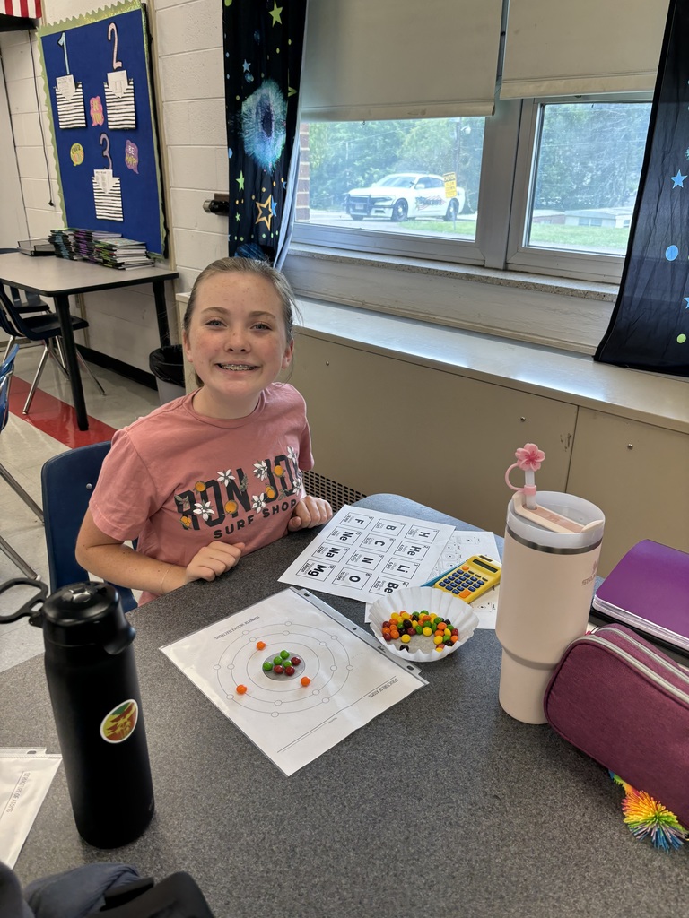 A student uses candy to model the structure of atoms.
