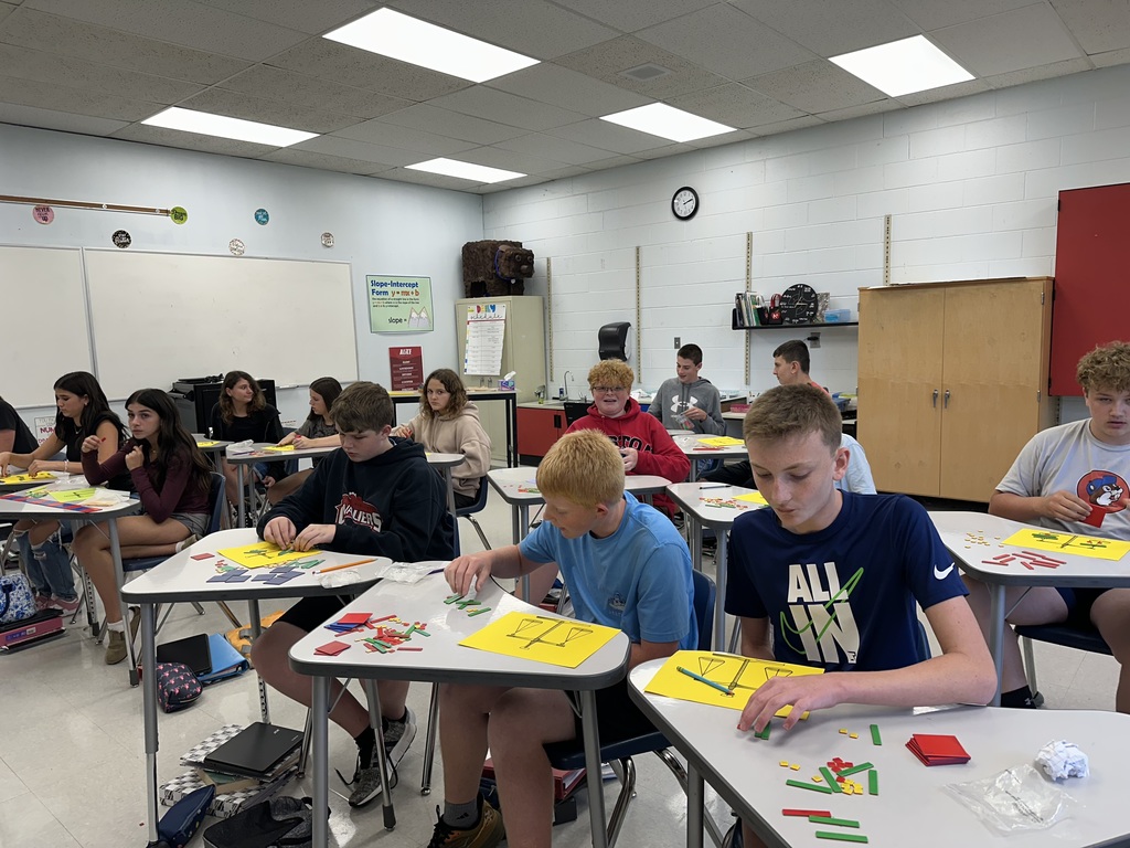 Students use algebra tiles in a classroom.