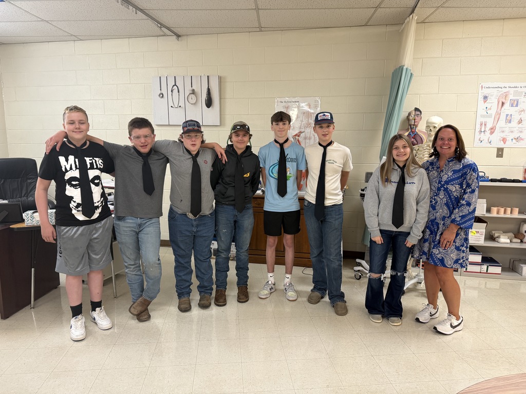 Students wearing ties stand with their teacher.