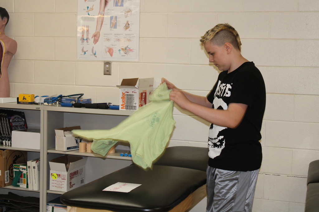 A student folds a shirt.