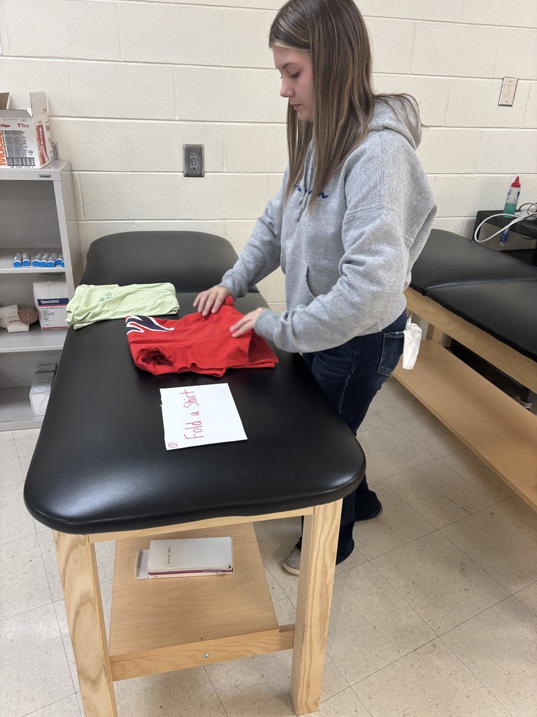 A student folds a shirt.