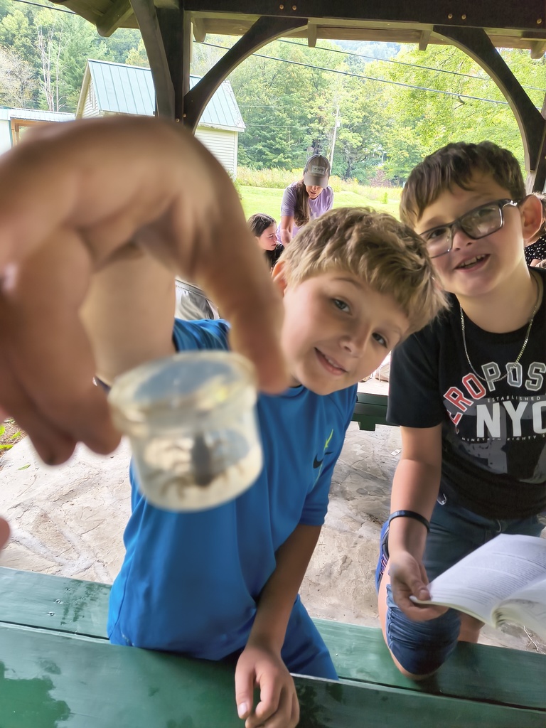 Students showing insect specimen