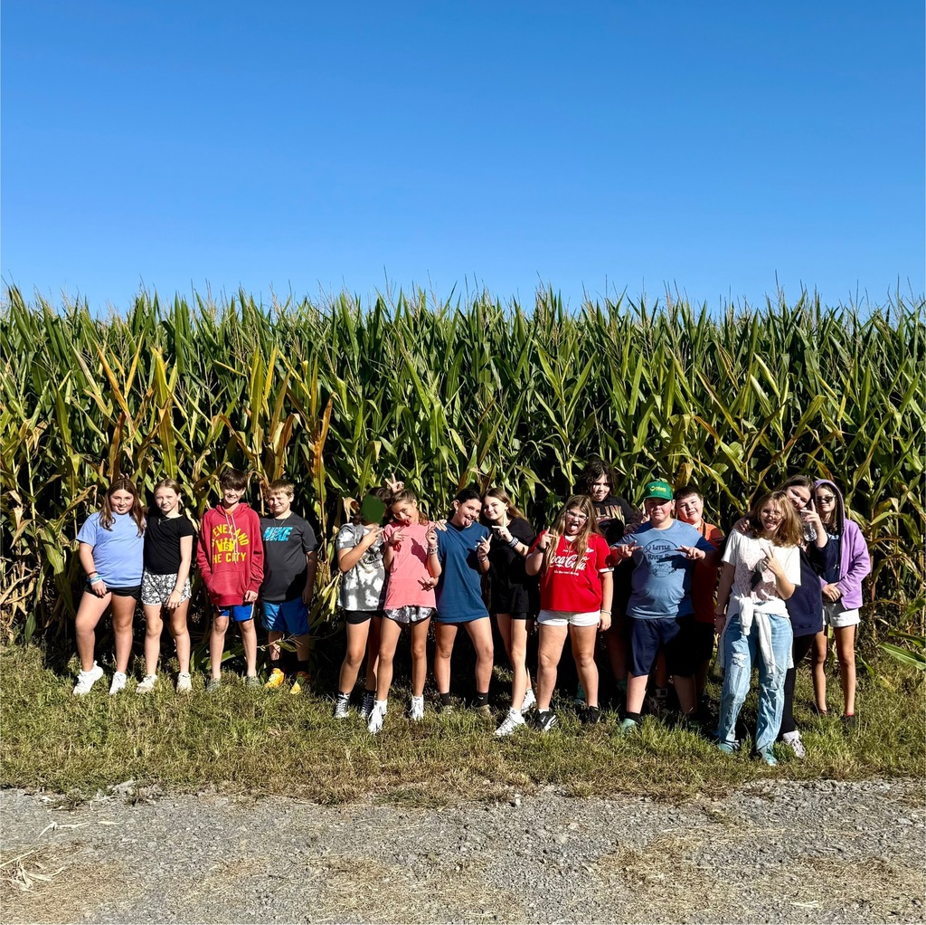 Students stand in front of a cornfield.