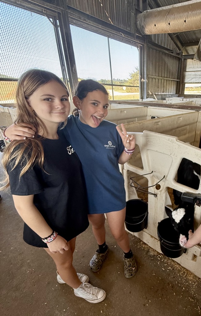Students pose with a calf.