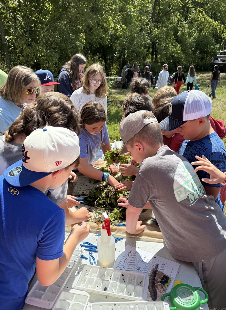 Students work with water cress on a table.