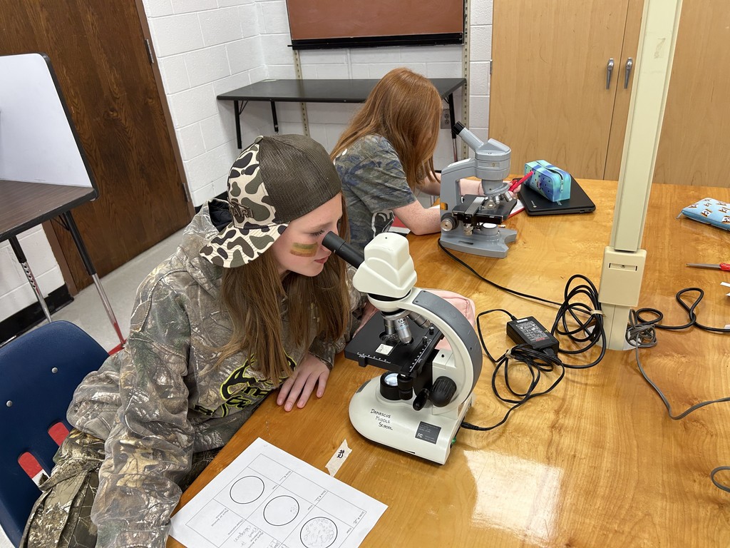 Students use microscopes in a science lab.