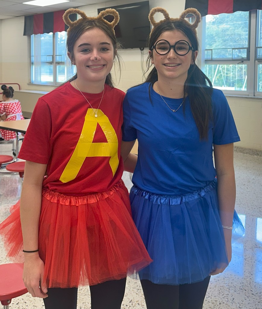 Students in costume pose in a school.