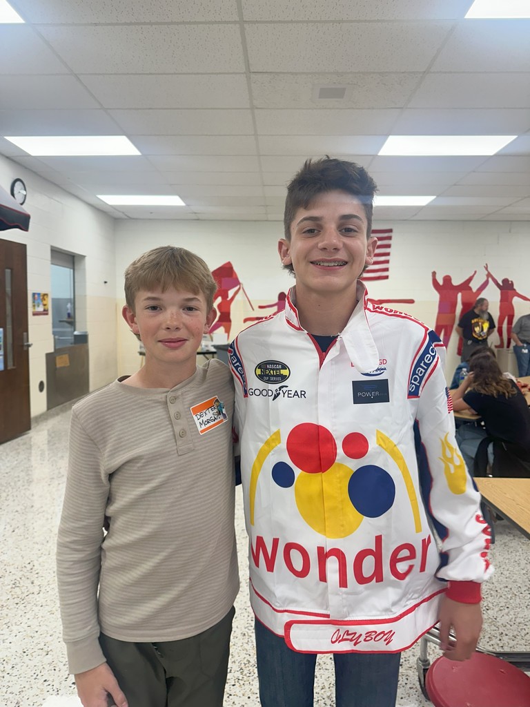 Students in costume pose in a school.