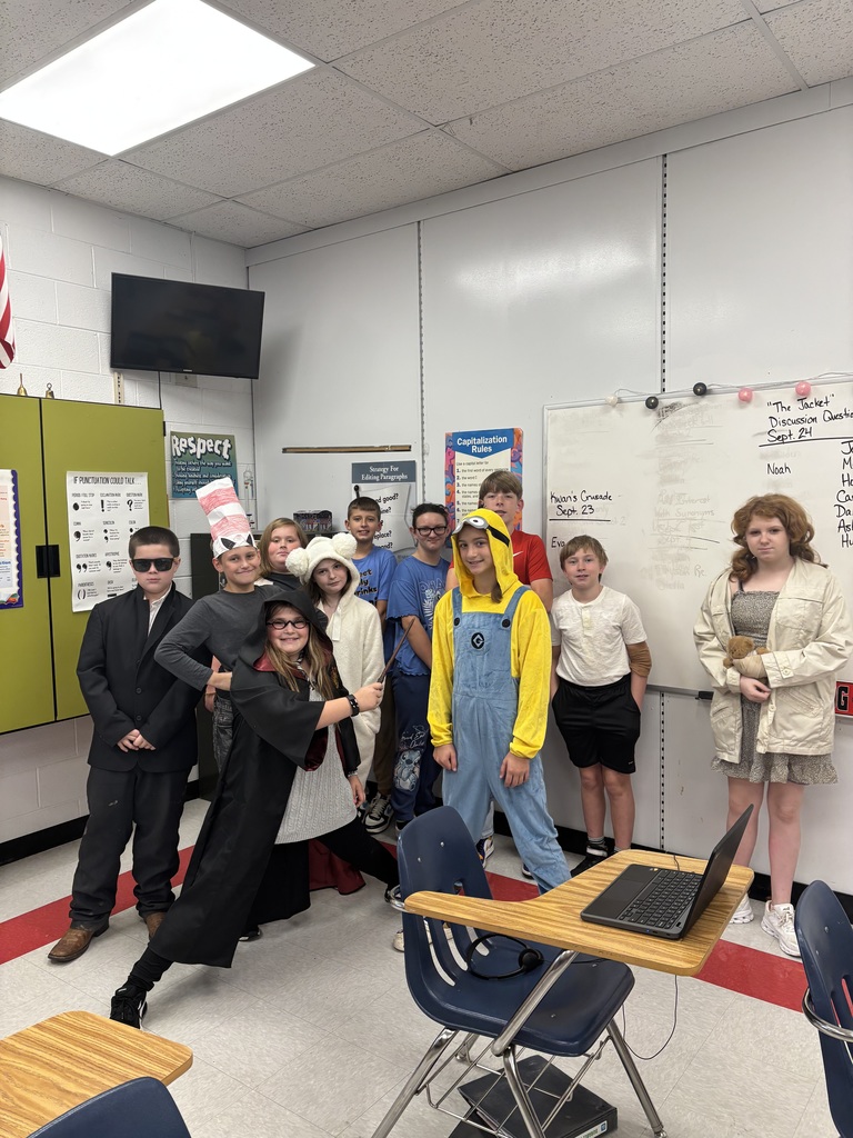 Students in costume pose in a school.