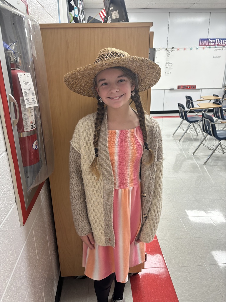 A student in costume poses in a school.