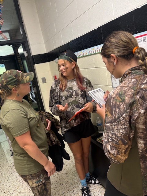 Students dressed in camo work on math problems.
