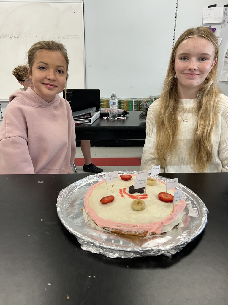 Students display their edible cell project.