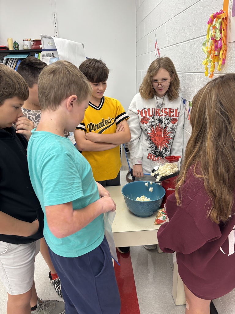 Students pop popcorn with an air popper.