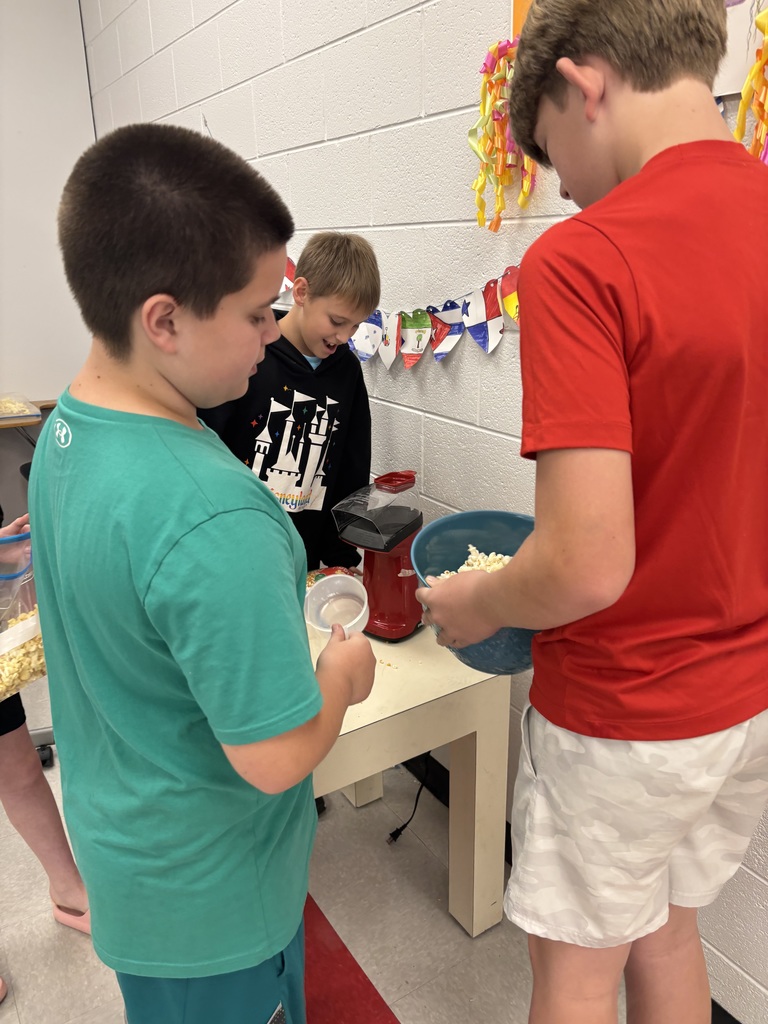 Students pop popcorn with an air popper.