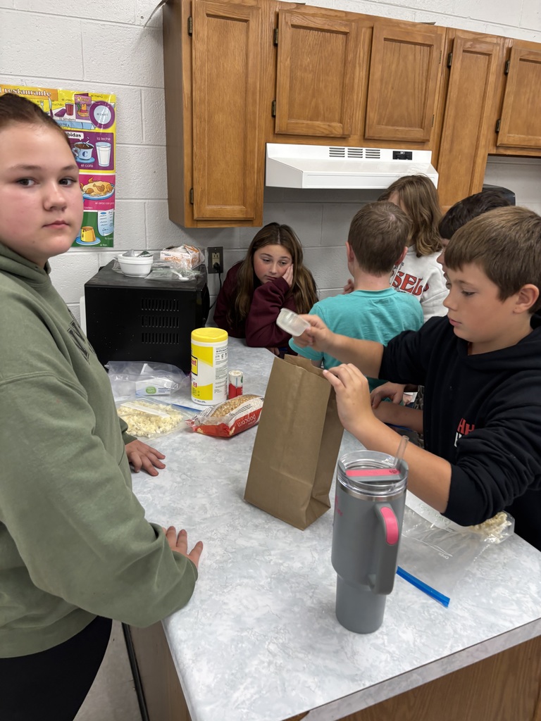 Students put popcorn in a paper bag.