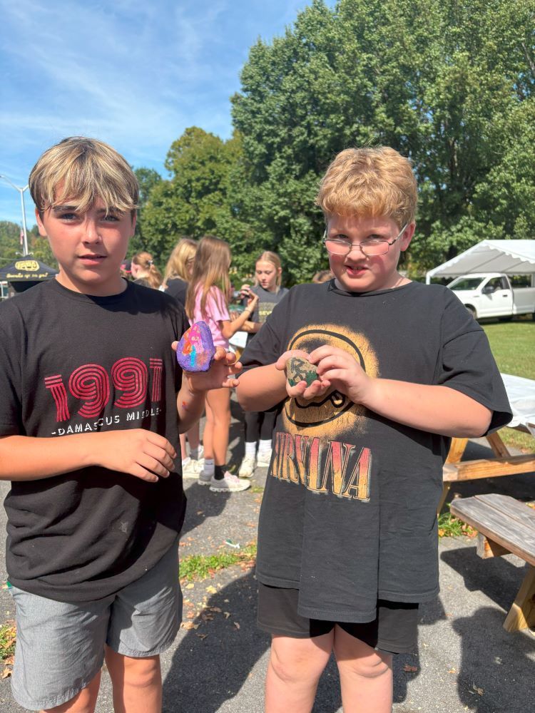 Two students show off their painted rocks.