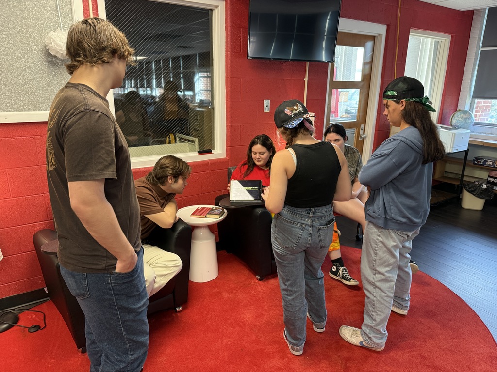 Students work on a video in a library.