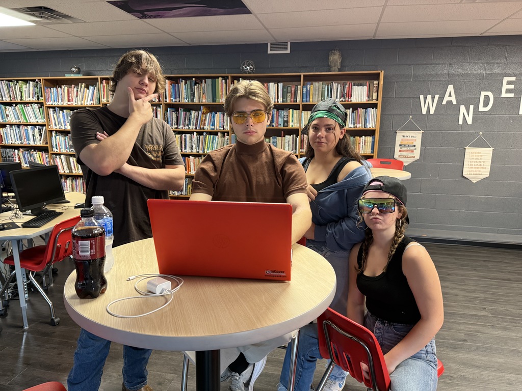 Students work on a video in a library.