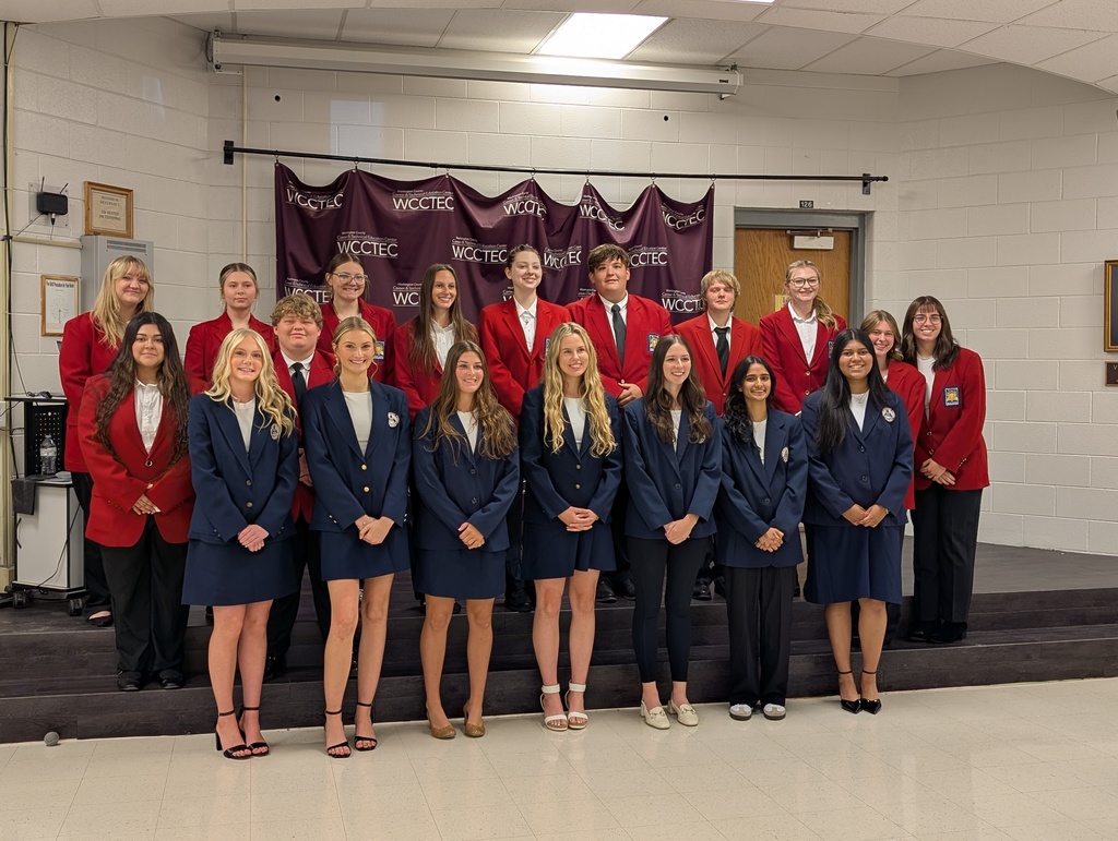 Students pose on a stage.