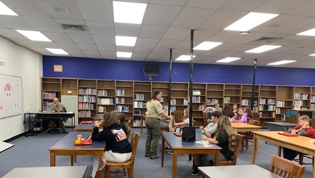 Students listen to park rangers while eating lunch.
