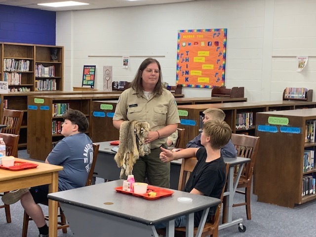 Students listen to park rangers while eating lunch.