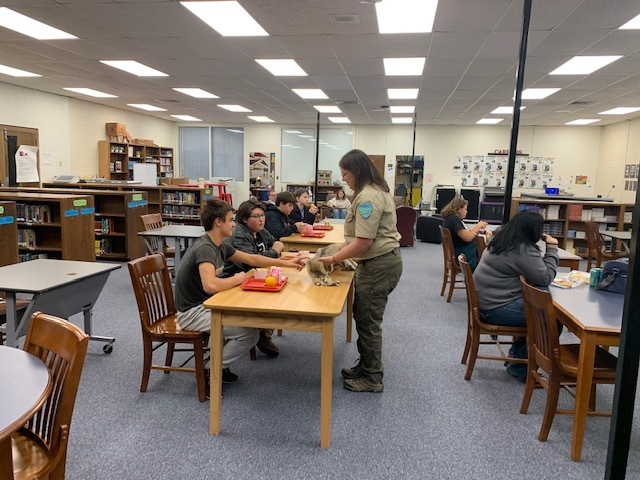 Students listen to park rangers while eating lunch.
