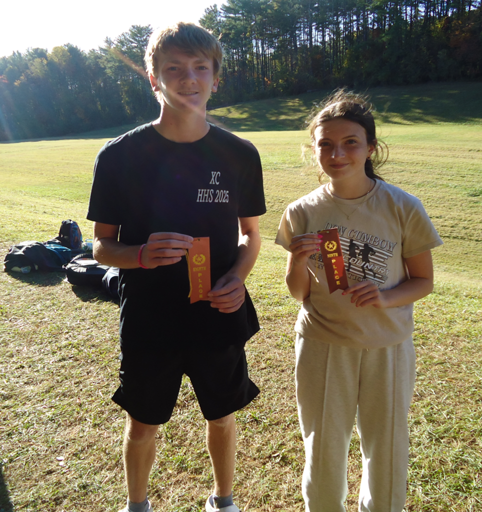 Two students hold ribbons on a running course.