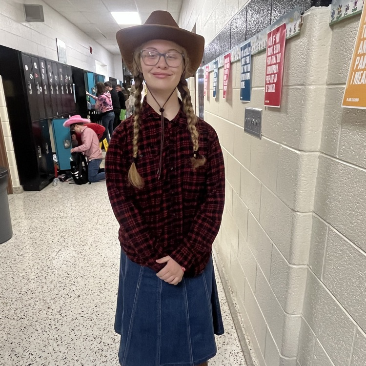 A student poses in a cowboy hat and boots.