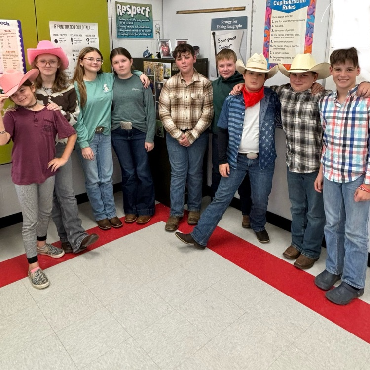 Students pose in cowboy hats and boots.