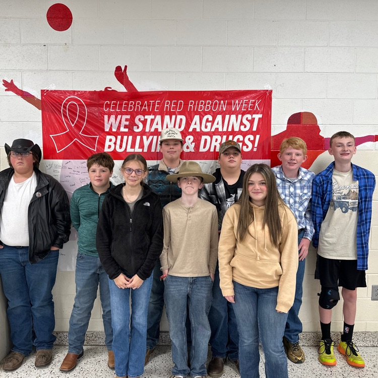 Students pose in cowboy hats and boots.