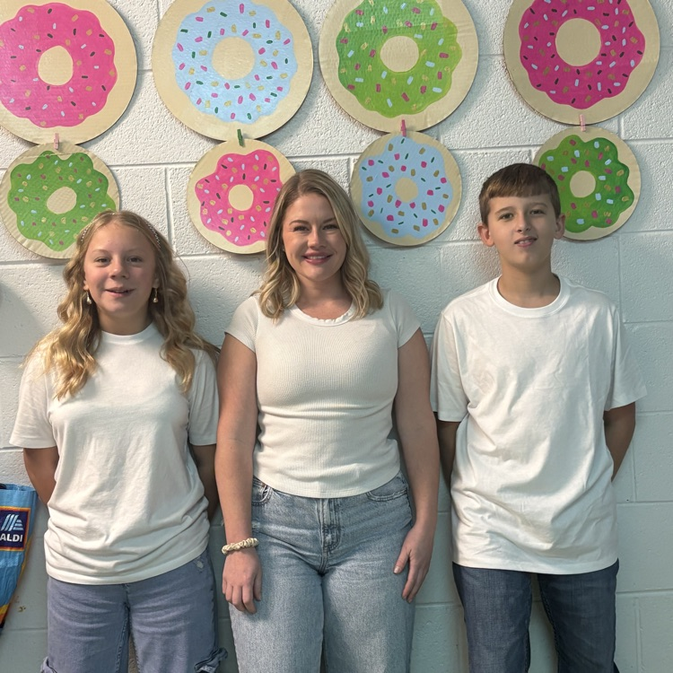 Two students and a teacher are dressed alike.