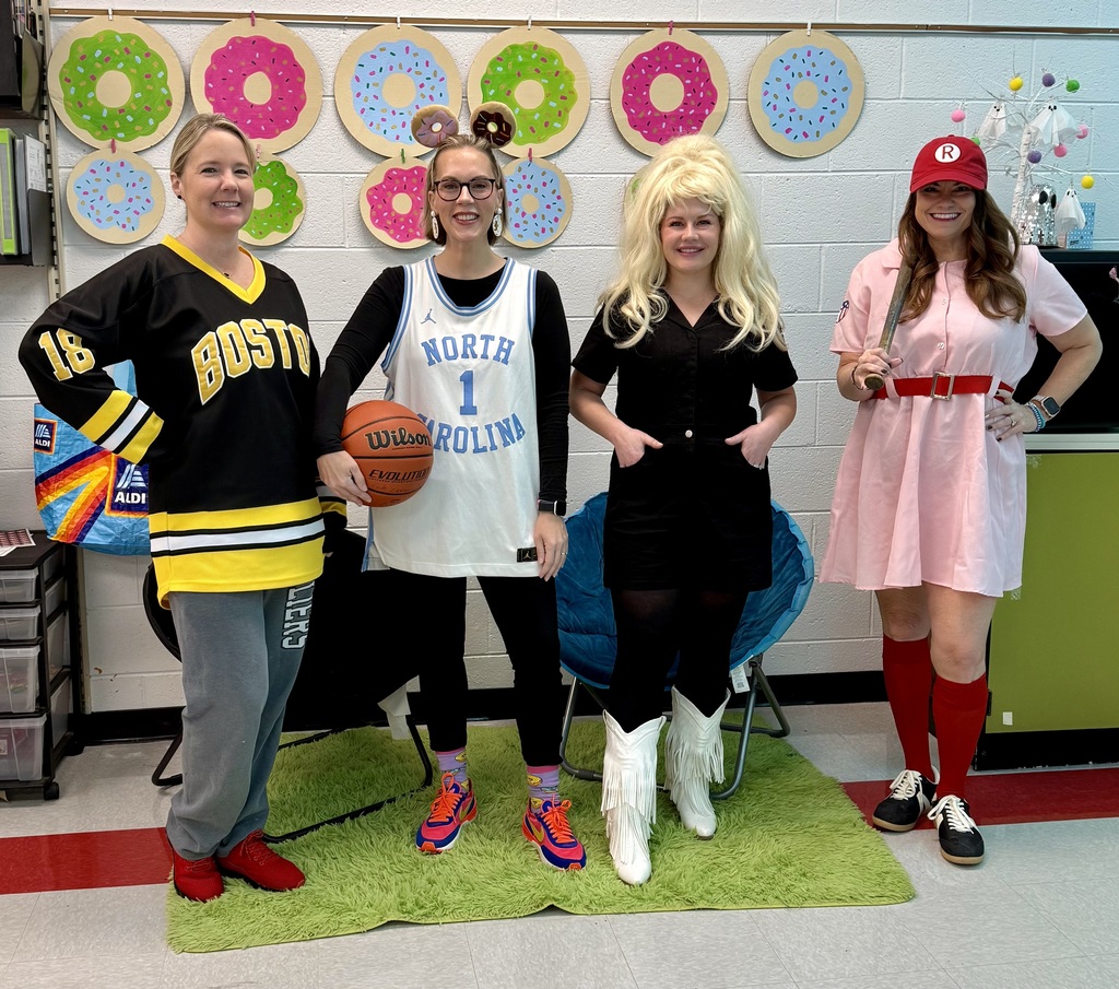 Teachers pose in Halloween costumes.