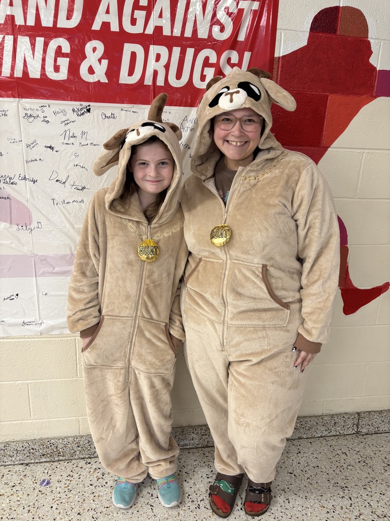 A teacher and student pose in matching Halloween costumes.