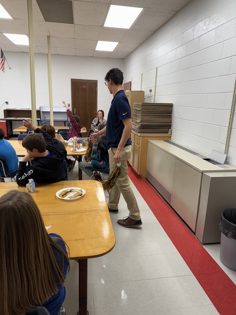 A man gives a student a prize for asking a question.