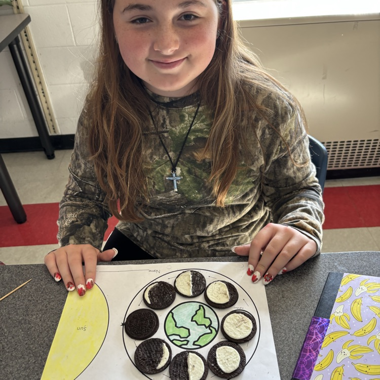 A student shows her Oreo moon phase model.