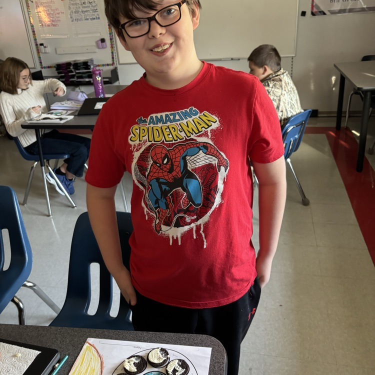 A student shows his Oreo moon phase model.