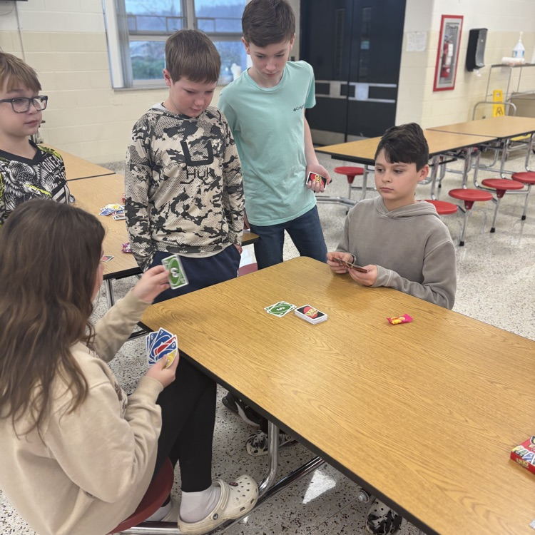 Students play UNO in a cafeteria. 