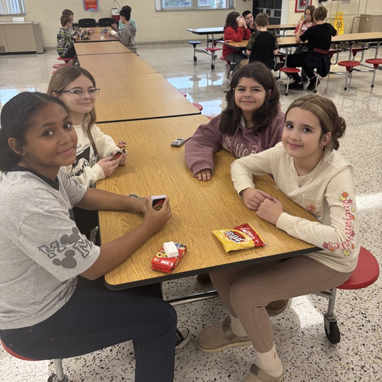 Students play UNO in a cafeteria.