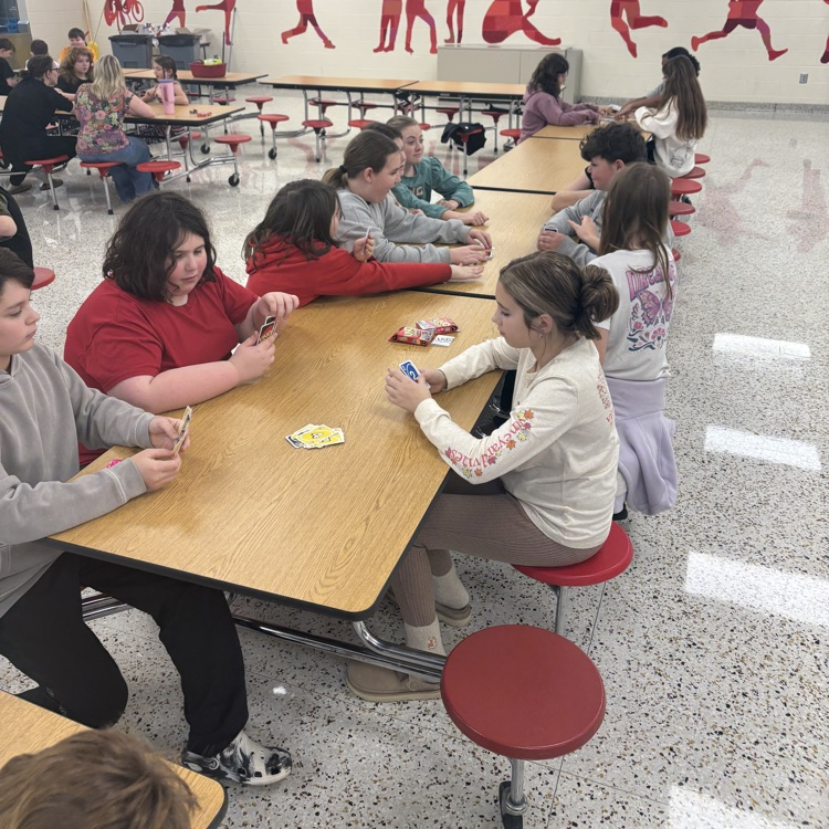 Students play UNO in a cafeteria. 