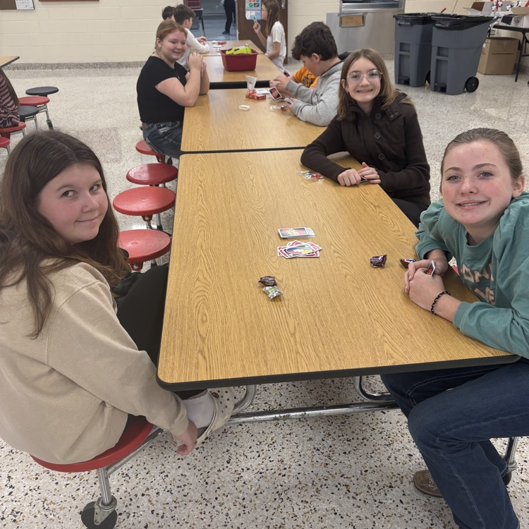 Students play UNO in a cafeteria.