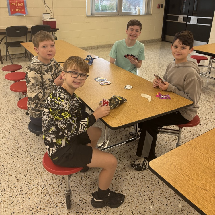 Students play UNO in a cafeteria.