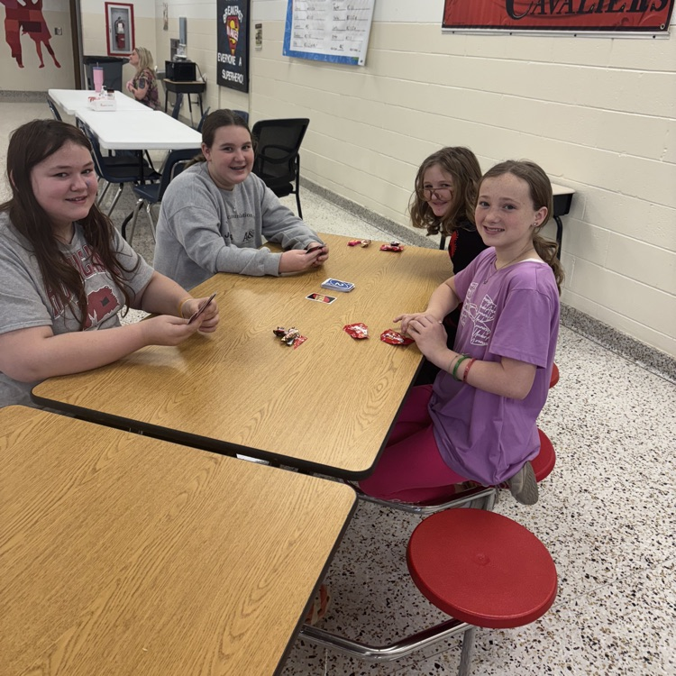 Students play UNO in a cafeteria.