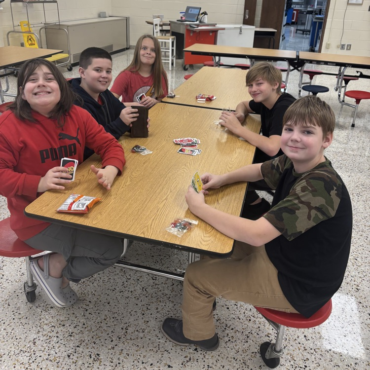 Students play UNO in a cafeteria.