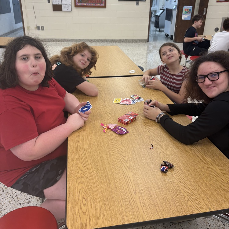 Students play UNO in a cafeteria.